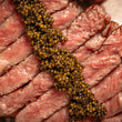 Load image into Gallery viewer, A close up of black caviar on a cut steak