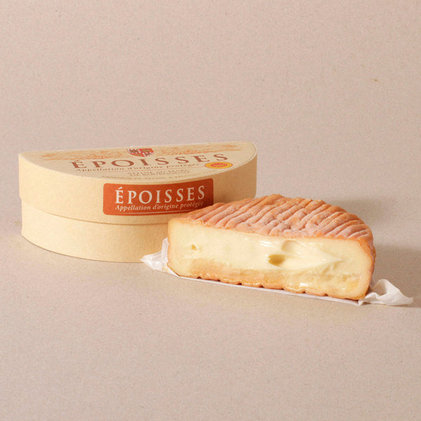 Epoisses cheese displayed in half moon as the fromage case is in the background displaying the label