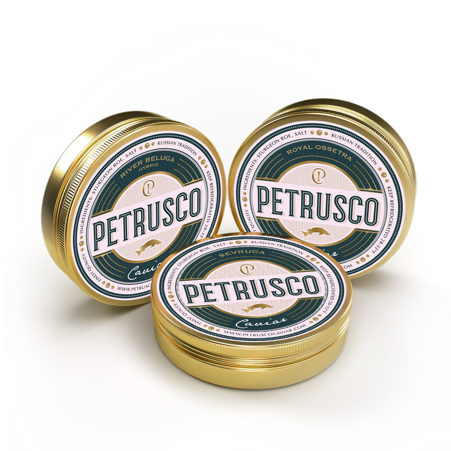 Closed tins of Petrusco Royal Ossetra, River Beluga, and Limited Edition Sevruga caviar sit side by side.