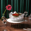 Load image into Gallery viewer, Petrusco Wild Alaska Salmon Roe tin on ice in a gold-rimmed glass bowl on a marble stand with crystal glasses, pink flower, and green velvet backdrop.
